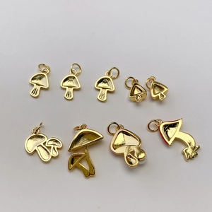Makroansicht von neun verschiedenen vergoldeten Pilzanhängern für DIY-Schmuck