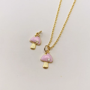 Detailansicht der Goldkette mit rosa Pilzanhänger und weißen Emaille-Punkten