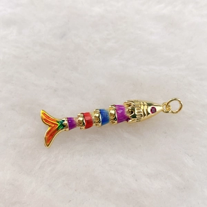 Macro shot of colorful tropical fish pendant with enamel segments and pink gem eye