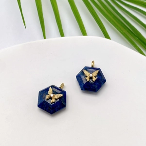 Lapis lazuli hexagonal pendants with gold butterfly and zircon on white platform