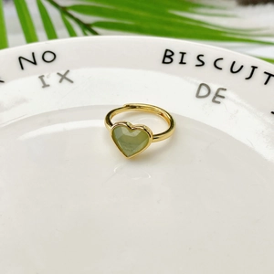 Dettaglio di pietra naturale verde a cuore su anello dorato aperto regolabile
