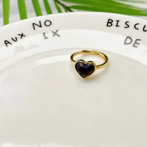 Dettaglio dell'anello regolabile in metallo dorato con pietra viola a forma di cuore
