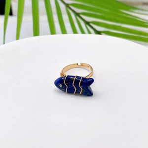Detail of fish-shaped lapis lazuli ring with wire-wrapped gold-tone band and small rhinestone