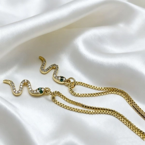 Elegant gold snake pendant necklace with green emerald eyes and white zircon stones