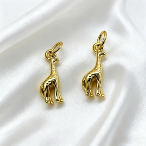 Detail of gold giraffe pendants with polished mirror finish and delicate spotted textures