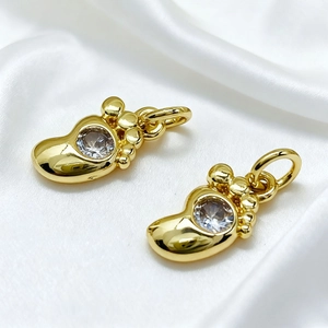 Macro detail of gold-plated boot pendants with sparkling zircon stones for jewelry DIY