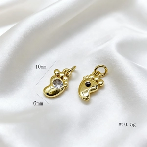 Detailed size view of gold baby feet charms showing 10mm height and 6mm width