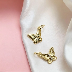 Detail of golden butterfly charms with polished finish and sparkling crystal accents