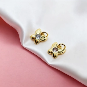 Detailed macro shot of golden butterfly charms with embedded clear zircon stones