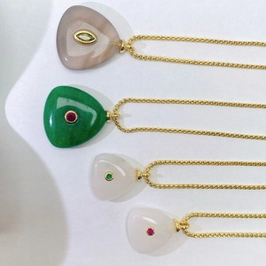 Detailed close-up of natural stone necklaces with gold metal chains in various colors