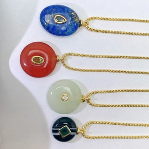 Detail of four natural stone necklaces with gold chains in lapis and agate stones