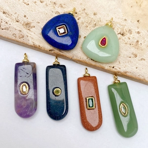 Détail macro de six pendentifs en pierre naturelle avec placage or et zircons