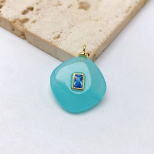 Detailed macro view of an irregular aqua stone pendant with a deep blue gemstone inlay