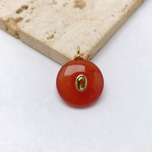 Detail of red agate peace buckle pendant with inlaid yellow gemstone and gold clasp