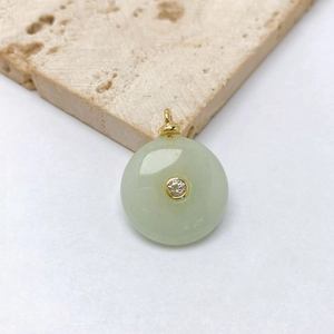 Detail shot of a green jade Ping An Kou pendant with gold inlay and a sparkling zircon