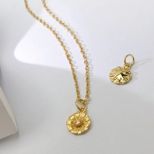 Detaillierte Nahaufnahme goldener Sonnenblumen-Anhänger an einer feinen Kette