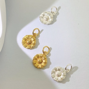 Detail von vier Gänseblümchen-Anhängern in Gold und Silber für Halsketten