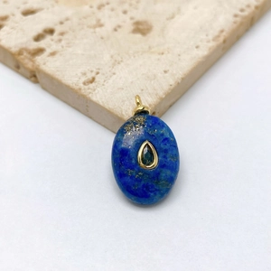 Macro shot of oval lapis lazuli pendant with gold inlay and teardrop gemstone detail