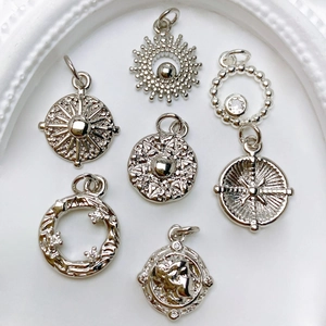 Macro shot of six vintage silver sun and cameo pendants for DIY jewelry making
