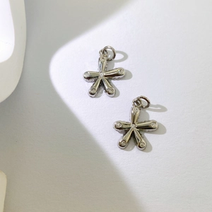 Makro-Detail von silbernem Blumenanhänger mit Zirkonia-Inlay und glatter Oberfläche