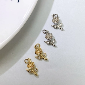 Macro shot of rose flower charms in gold and silver finish with zircon accents
