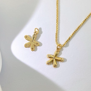 Details einer goldenen Box-Kette und zwei Blumenanhängern mit weißen Kristallen