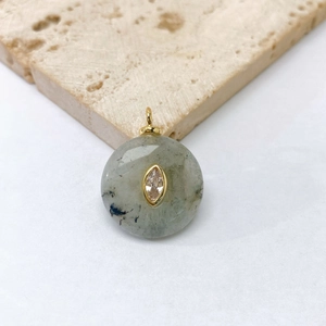 Detail of round natural green stone pendant with golden inlay and marquise zircon