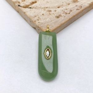 Gros plan d'un pendentif rectangulaire en jade vert clair avec zircon blanc et doré