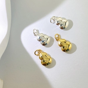 Makroansicht polierter Hulu-Anhänger in Gold und Silber für DIY-Schmuckherstellung