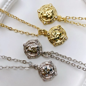 Close-up of vintage sunburst coin pendants with micro-inlaid rhinestones in gold and silver
