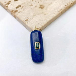 Detailed macro view of a rectangular blue lapis stone pendant with a green crystal inlay