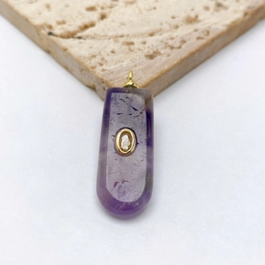Détail d'un pendentif en améthyste violette avec incrustation de zircon doré sur pierre