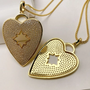 Detail of gold heart pendant with star cutout and honeycomb back showing zircon pave work