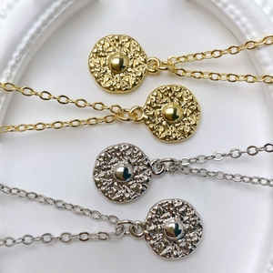 Detail of four retro sunburst medallion pendants in gold and silver finish with O-chains