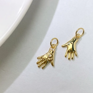 Detailed close-up of gold palm flower pendants with eye relief and sparkling zircons