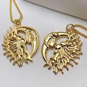 Detailed close-up of sun and moon face charms on gold plated pendant necklaces