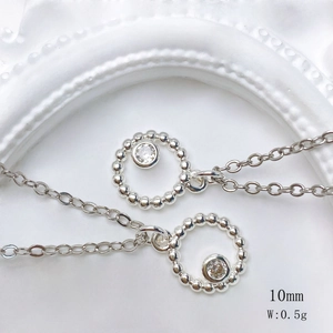 Detail showing a 10mm silver sun pendant necklace with sparkling round cubic zirconia