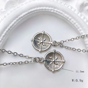 Macro shot of silver sun coin pendant with dimensions 11.5mm diameter and 0.9g weight