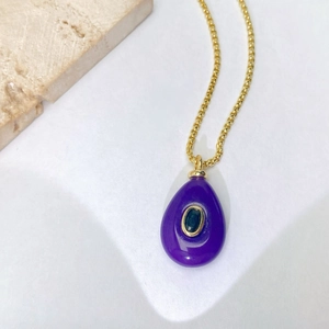 Détail du pendentif goutte d'eau violette avec pierre verte et chaîne en or