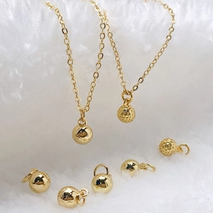 Detailed close-up of golden spherical pendants with smooth and textured honeycomb finishes