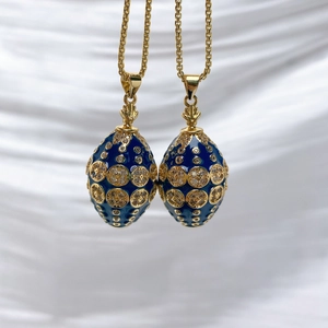 Detailed macro of Fabergé-style egg pendants with blue enamel and gold textured motifs