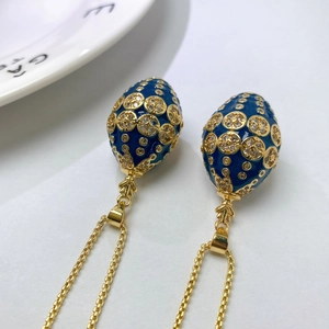 Detail of Russian style blue enamel egg pendant necklace with gold hollow pattern and zircon