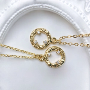 Close-up of golden sun-textured round pendants with inlaid sparkling zircon crystals
