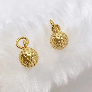 Close-up of golden spherical pendants with honeycomb texture and round hanging rings