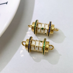 Detail of gold-plated white enamel cylinder beads with colorful cubic zirconia star pattern