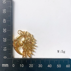 Detailed view of 30mm golden sun and moon pendant showing size on a ruler and 5g weight