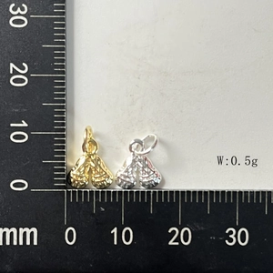 Macro shot of 10mm gold and silver flower charms weighing 0.5g on a black scale