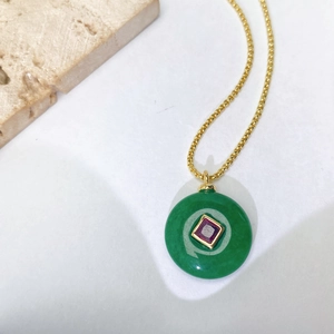 Détail du pendentif en jade vert rond avec zircon violet carré et chaîne dorée élégante