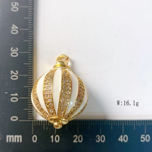 Detail view of 25mm striped enamel ball pendant measuring 16.1g on a scale