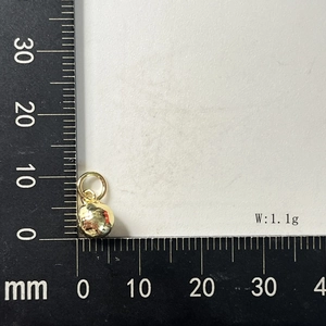 Detailed macro view showing an 8mm golden spherical pendant with 1.1g weight on ruler